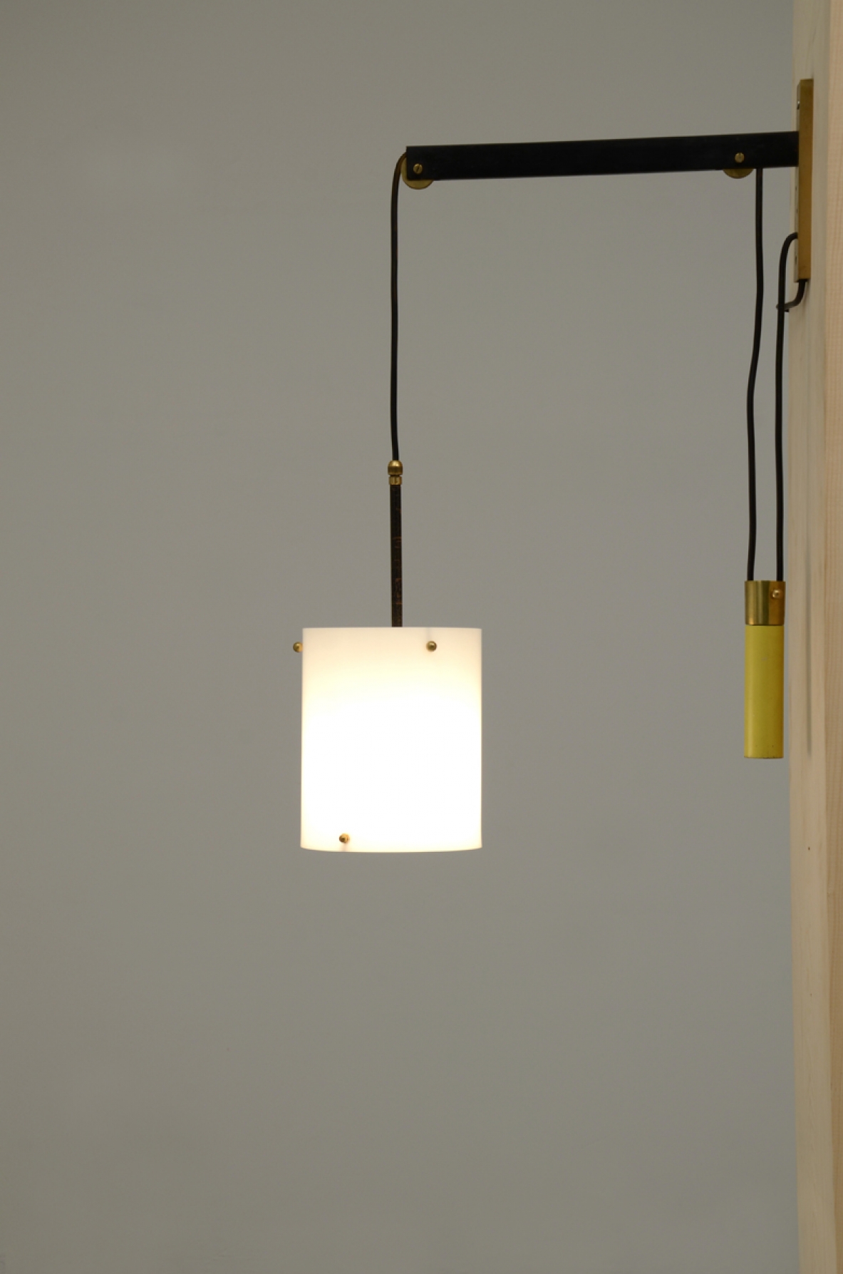 Adjustable wall lamp with yellow weight and a white polypropylene shade. France, 1950's.