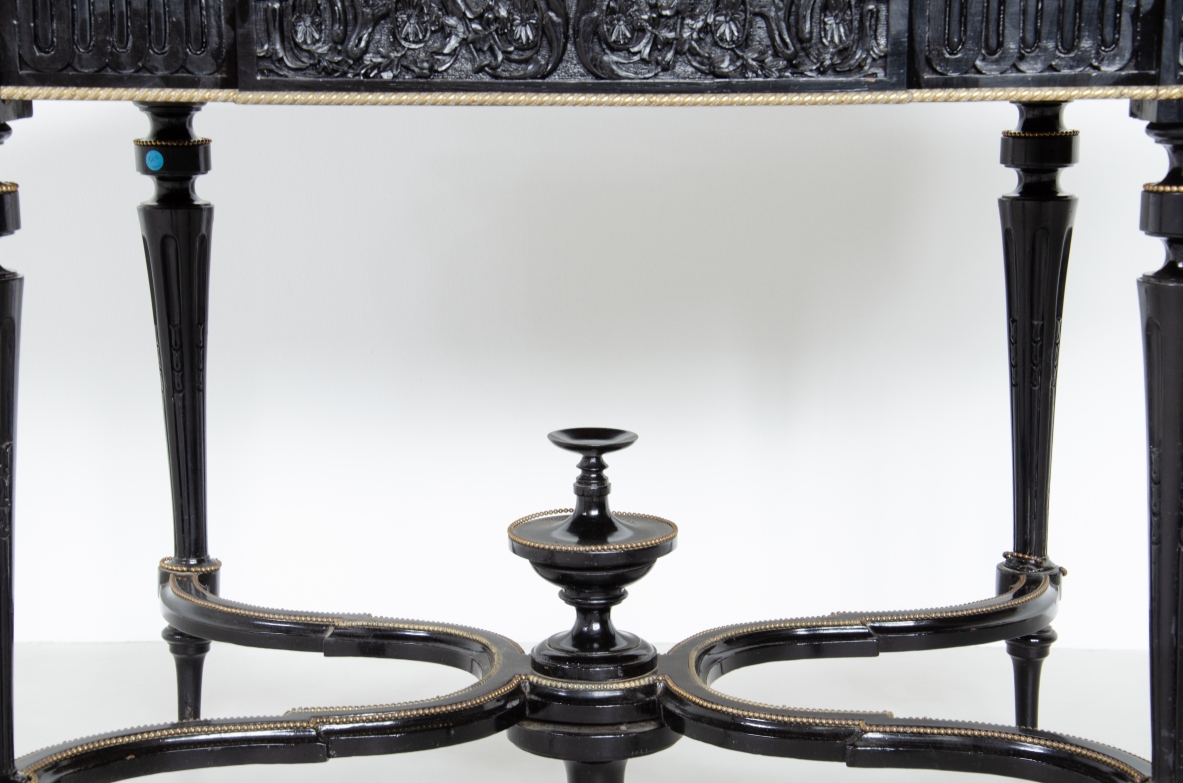 Center table in ebonized wood with thin turned legs and shaped top, brass profiles. France, 1870-1900.