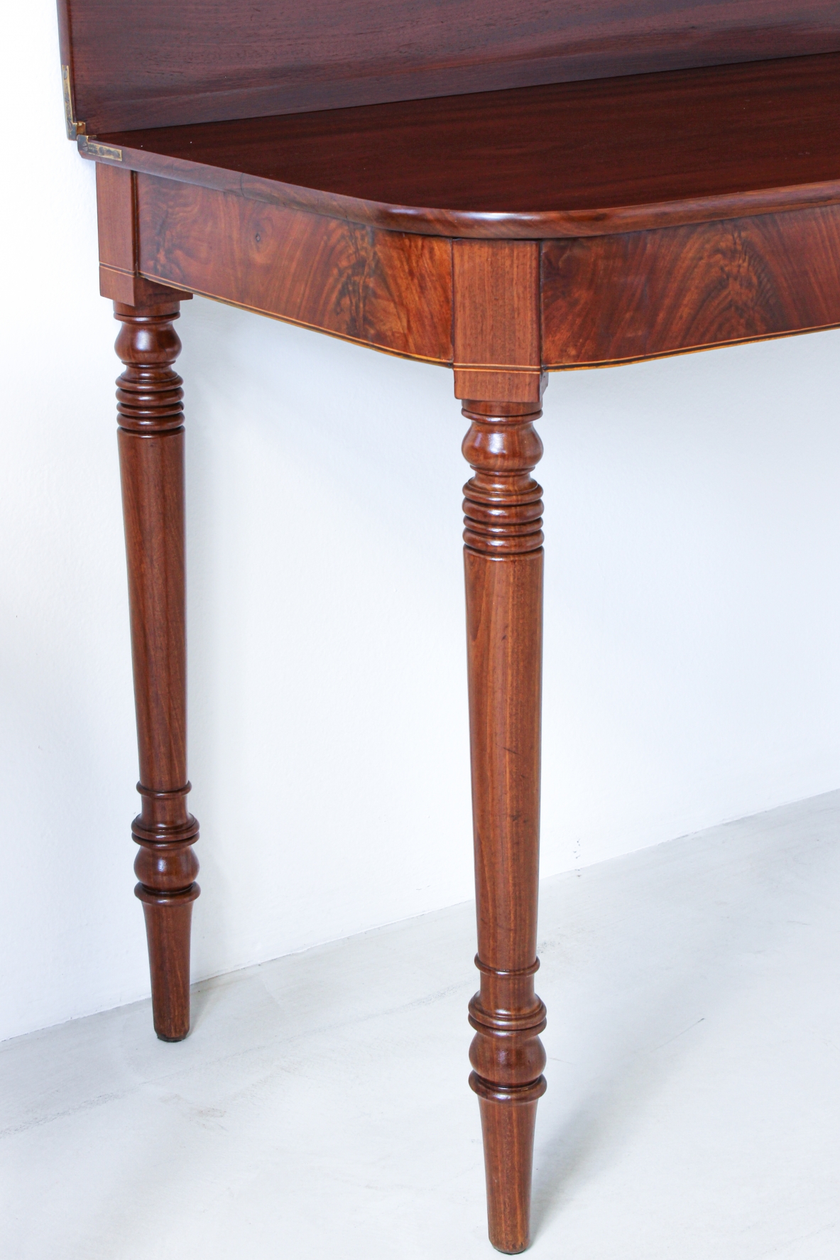 Pair of elegant consoles in mahogany with double book top and turned legs.