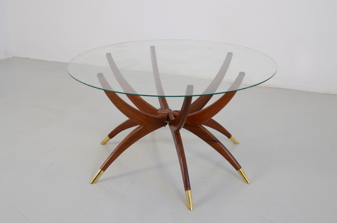 Elegante tavolino in mogano a sei razze in mogano con sottili puntali in ottone e piano in cristallo. Design Carlo de Carli, 1950ca.