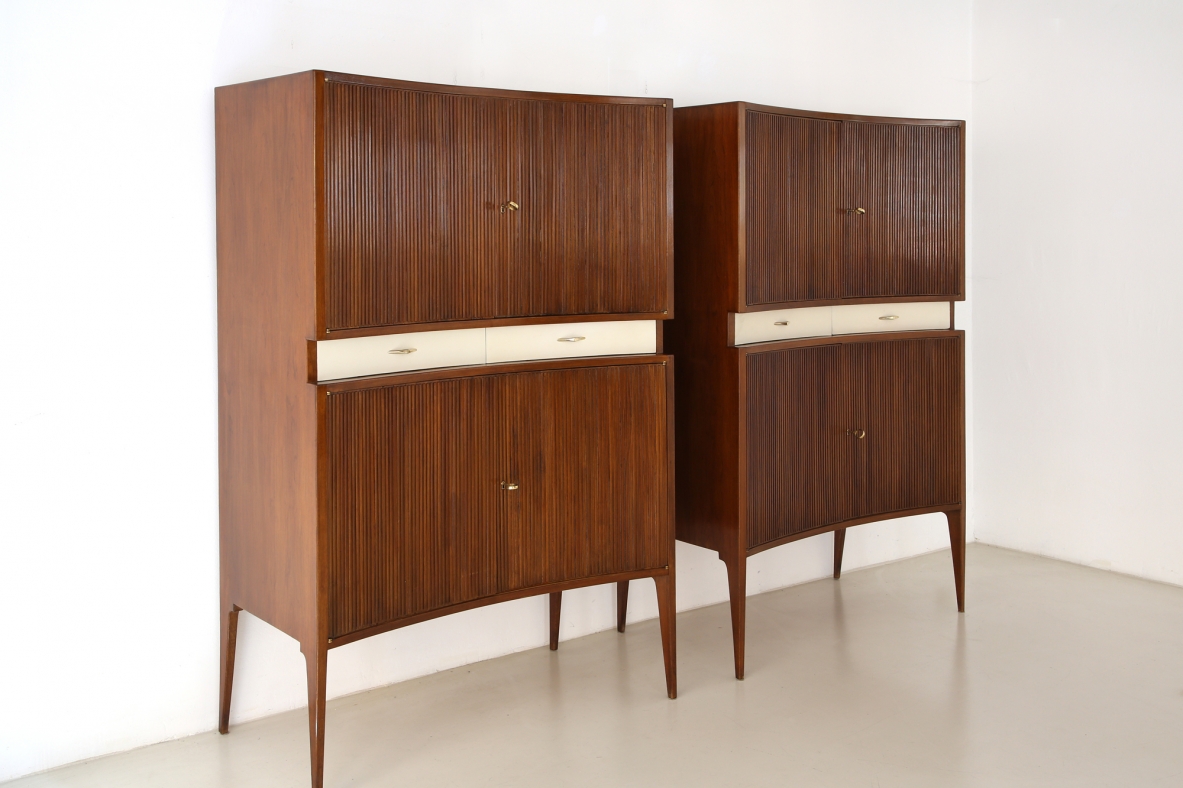 Elegante coppia di mobili con fronte convesso in legno grissinato, lunghi piedi sottili e due cassetti laccati al centro, attr. Guglielmo Ulrich, 1950ca.