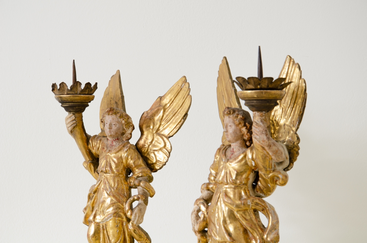 Pair of lacquered and gilded wood angels holding a cornucopia with a gilt metal crown.  Central Italy, Baroque period, second half of the 17th century.
