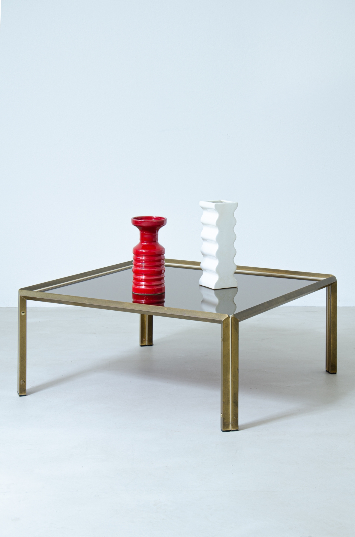 Willy Rizzo (1928-2013)  Tavolino in ottone e metallo verniciato con piano in vetro specchiato bronzo scuro.  Prodotto da Officine Willy Rizzo, Tivoli, 1970.