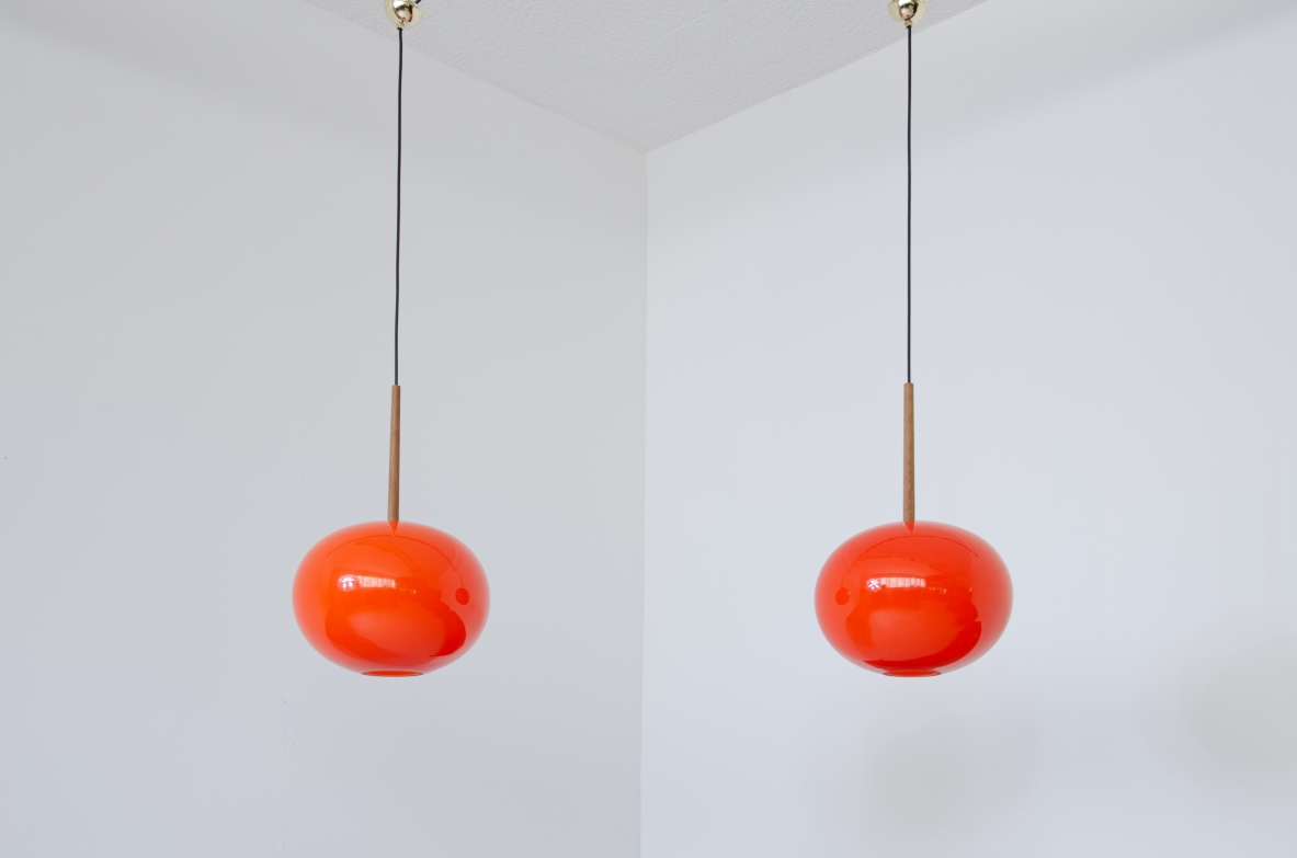 Pair of pendant chandeliers with wooden stem and red blown glass diffuser.  Scandinavia, 1950s.