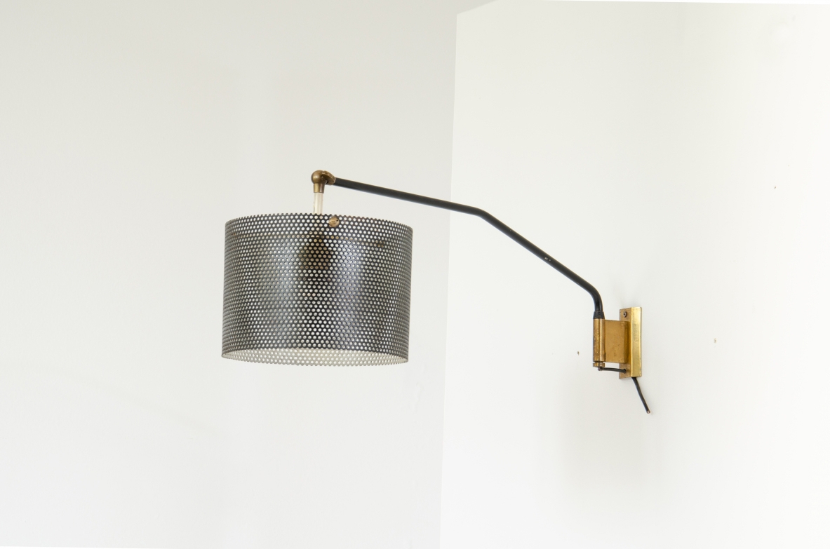 Stilnovo, 1950's wall lamp with adjustable arm and metal grid lampshade. Brass details.  Stamp of the manufacturer.