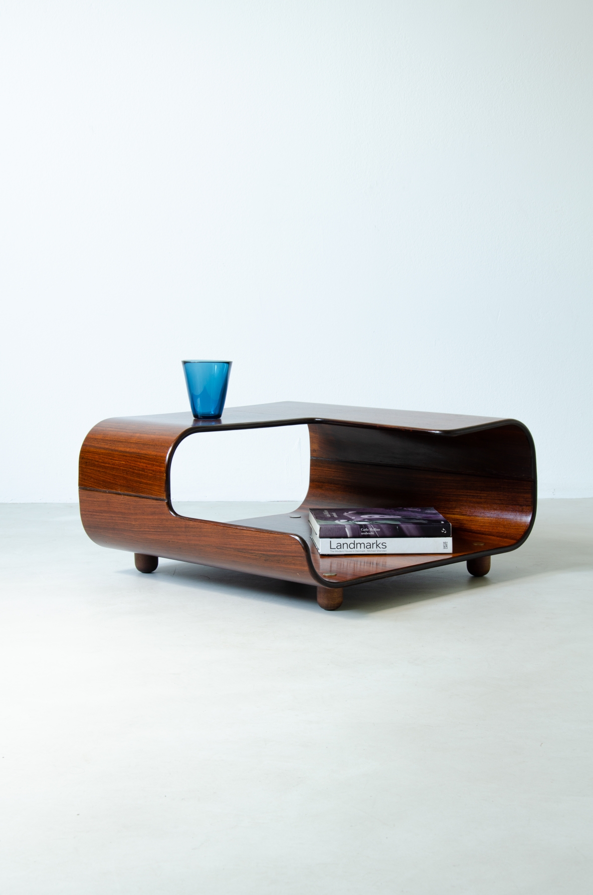 Tavolino in legno curvato con due piani sagomati.  Manifattura italiana, 1960ca.