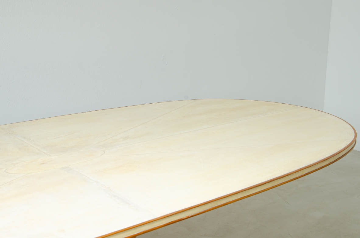 Grande tavolo con elegante struttura in legno biondo e piano rivestito in pergamena.  Manifattura italiana anni 50.