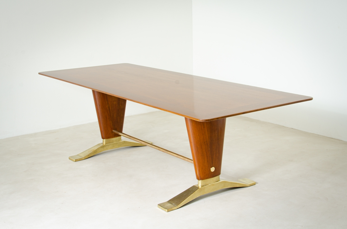 Grande tavolo in legno di noce con due montanti tenuti da traversa in ottone e importanti basamenti in fusione di bronzo.  Manifattura italiana 1940ca.