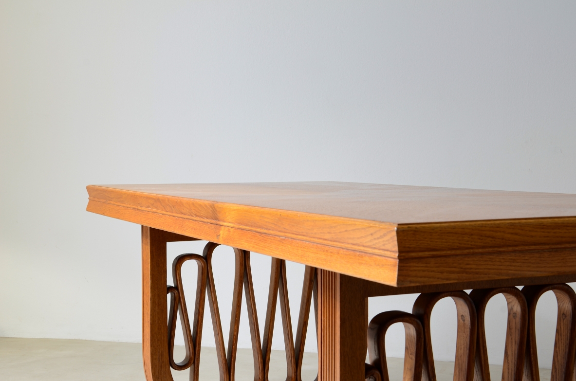 Straordinario tavolo in rovere con montanti grissinati e motivo a nastro nello stile dell'epoca, piano con spessore sagomato.  Manifattura italiana, 1940ca.