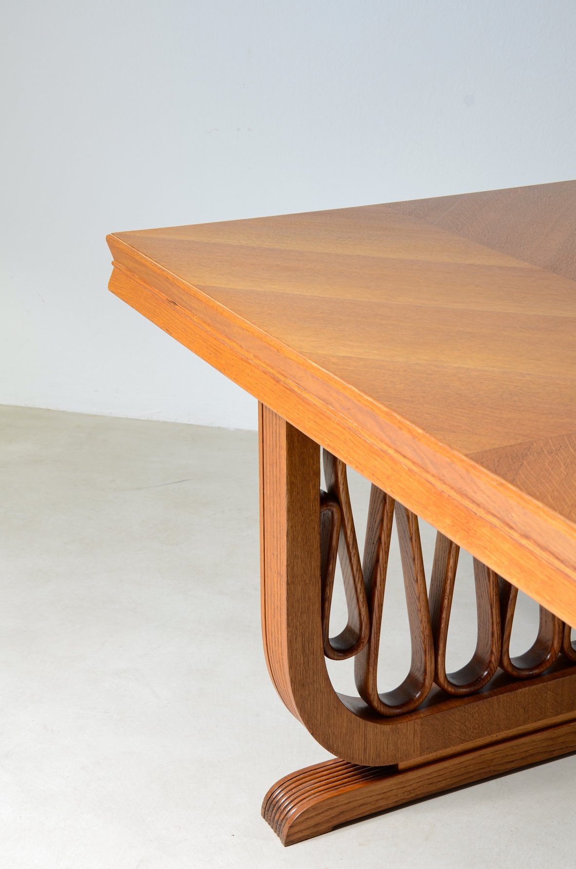 Straordinario tavolo in rovere con montanti grissinati e motivo a nastro nello stile dell'epoca, piano con spessore sagomato.  Manifattura italiana, 1940ca.