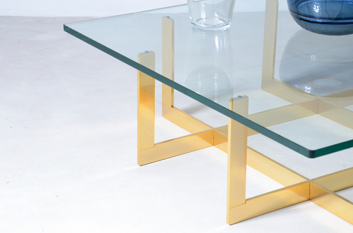 Elegante tavolo basso con struttura in ottone e piano in cristallo molato di forte spessore.