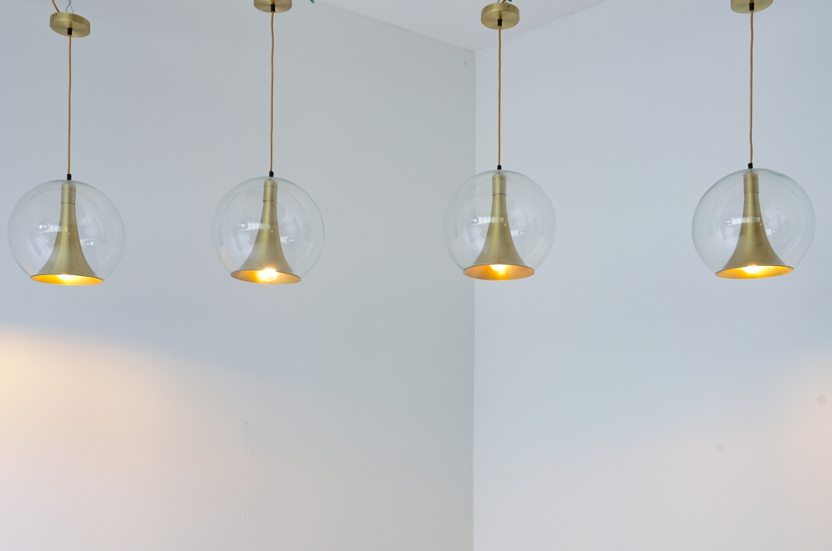 Quattro lampade a sfera direzionali realizzate in vetro soffiato e coni in ottone.  Manifattura muranese, 1960 ca.