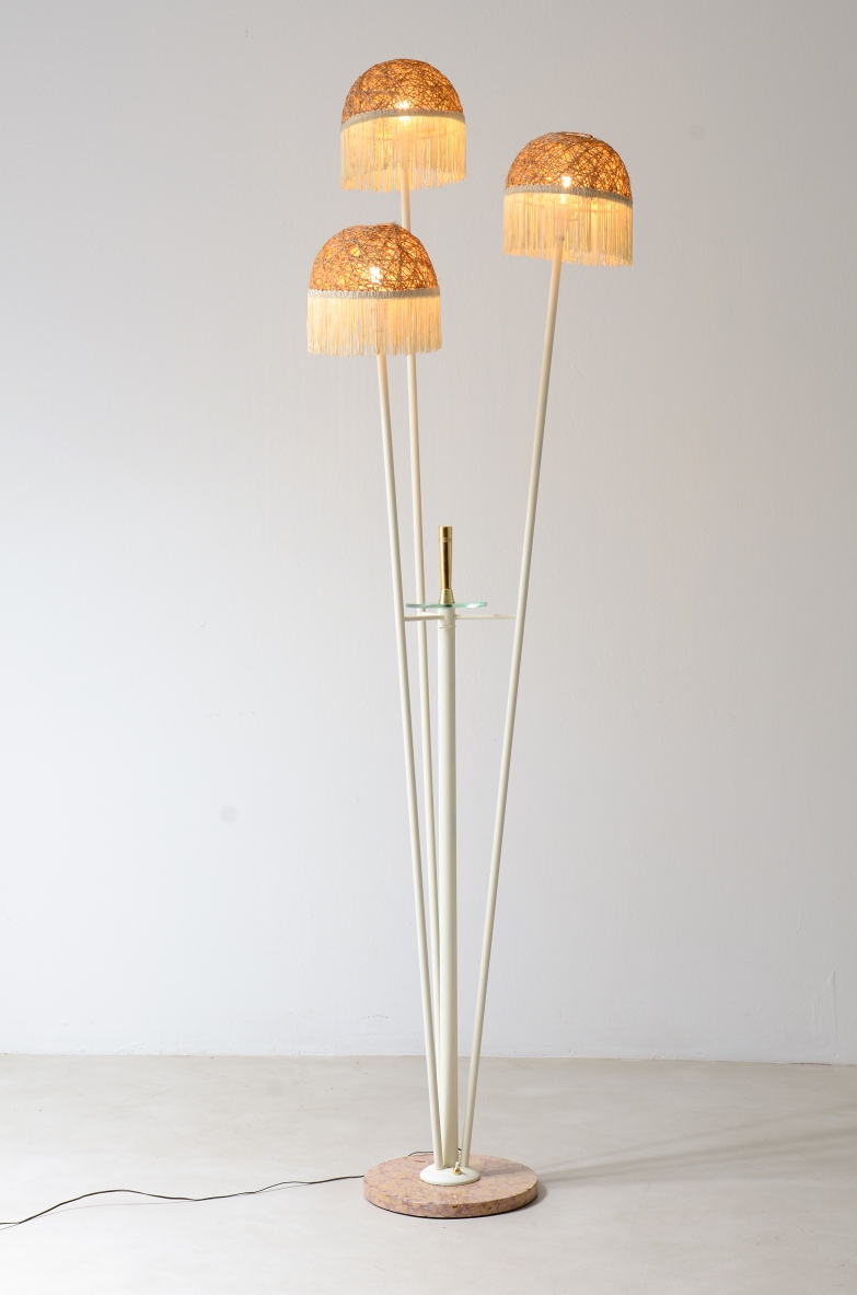 Three-arm floor lamp in painted metal with rattan shades and fabric fringes, base in red Verona marble and cut glass disc with brass tip.  Italian manufacture, ca. 1950.