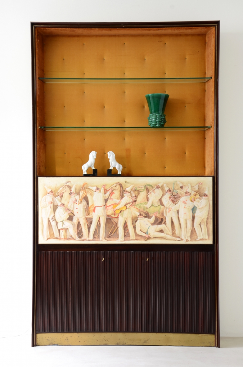 ABV Borsani  Grande mobile contenitore / bar / libreria con anta centrale dipinta su pergamena dall'artista Eugenio Rossi con scene della commedia dell'arte. Due ante in legno grissinato, contenitore bar illuminato con mensole in cristallo molato