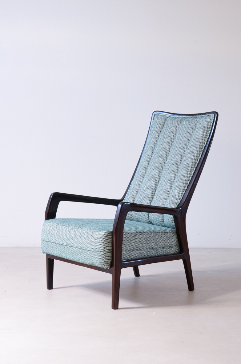 1950s reading armchair by ABV Borsani Varedo, with a tall inclined backrest, channel-stitched light blue upholstery, shaped dark wooden armrests and tapered legs.
