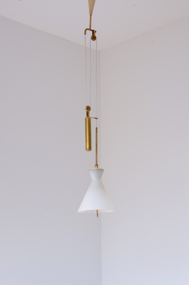 Stilnovo Milano height-adjustable pendant lamp, featuring a bell-shaped white opaline glass shade, vertical brass structure, pulley system and cylindrical brass counterweight, front view.