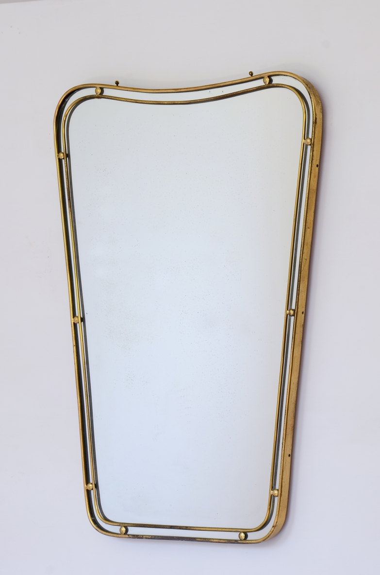Specchiera con cornice in ottone sagomato a doppio profilo con distanziatori a sfera.  Manifattura italiana 1950ca.