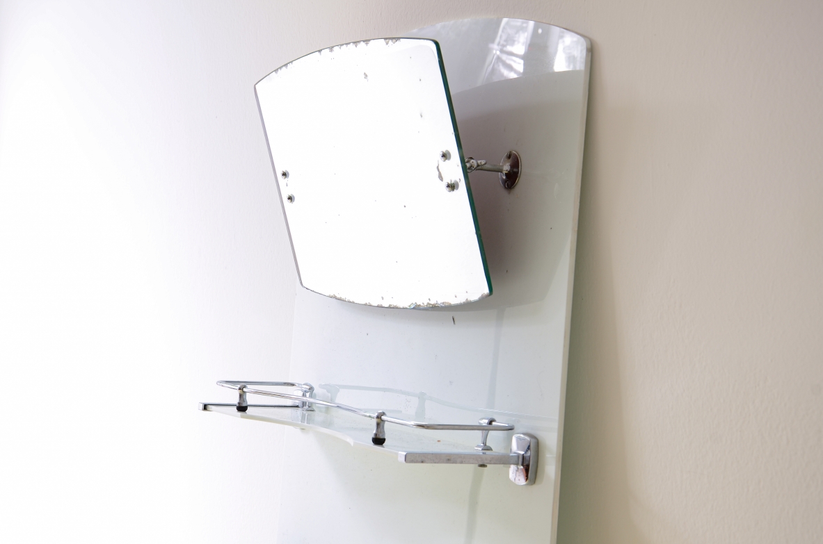 Specchio da bagno in opaline bianca con specchio basculante, mensola e porta saponette in metallo cromato.  Manifattura francese, 1930ca. Specchio da bagno in opaline bianca con specchio basculante, mensola e porta saponette in metallo cromato.  Manifattura francese, 1930ca.