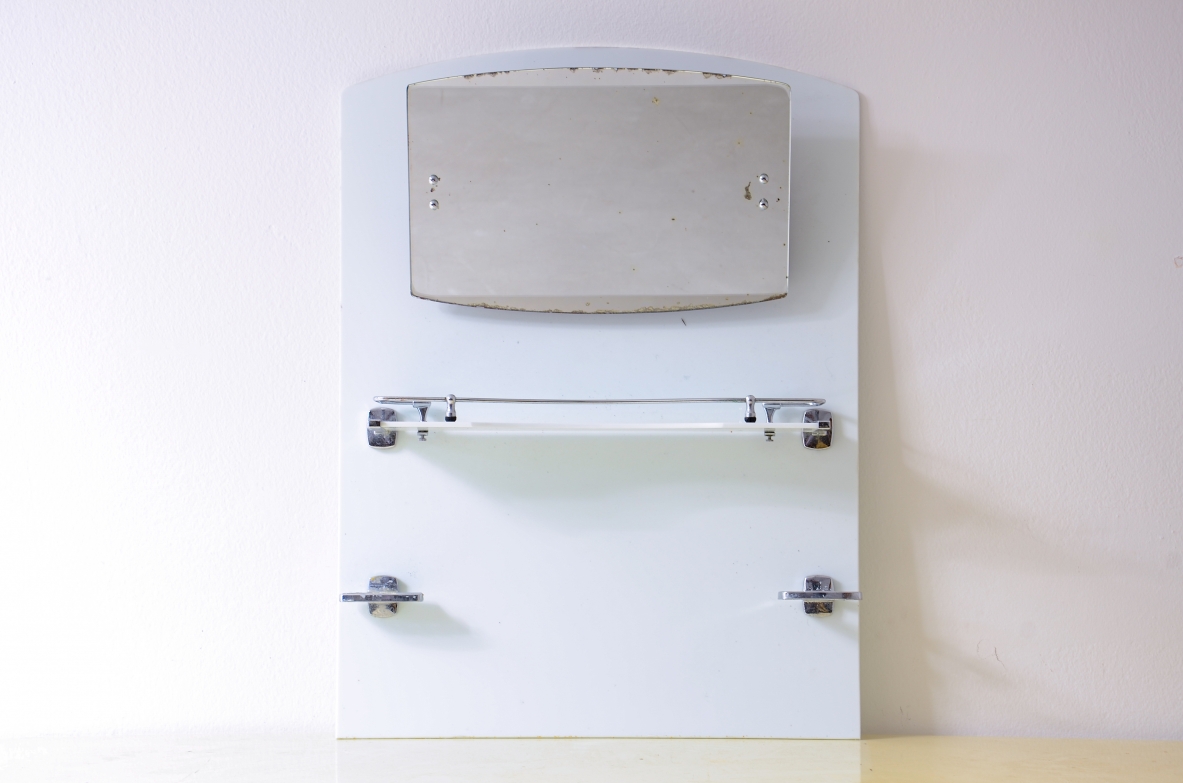 Specchio da bagno in opaline bianca con specchio basculante, mensola e porta saponette in metallo cromato.  Manifattura francese, 1930ca. Specchio da bagno in opaline bianca con specchio basculante, mensola e porta saponette in metallo cromato.  Manifattura francese, 1930ca.