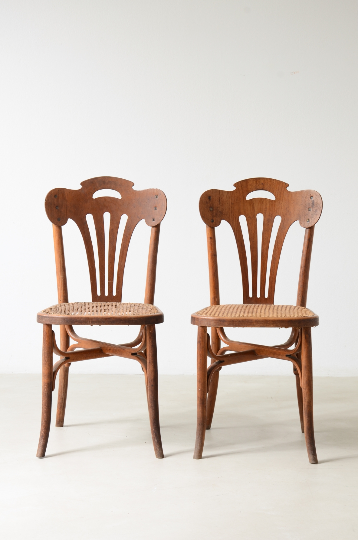 Four bent beech and perforated wood chairs with cane seats.  Thonet manufacture, Austria, circa 1920s.