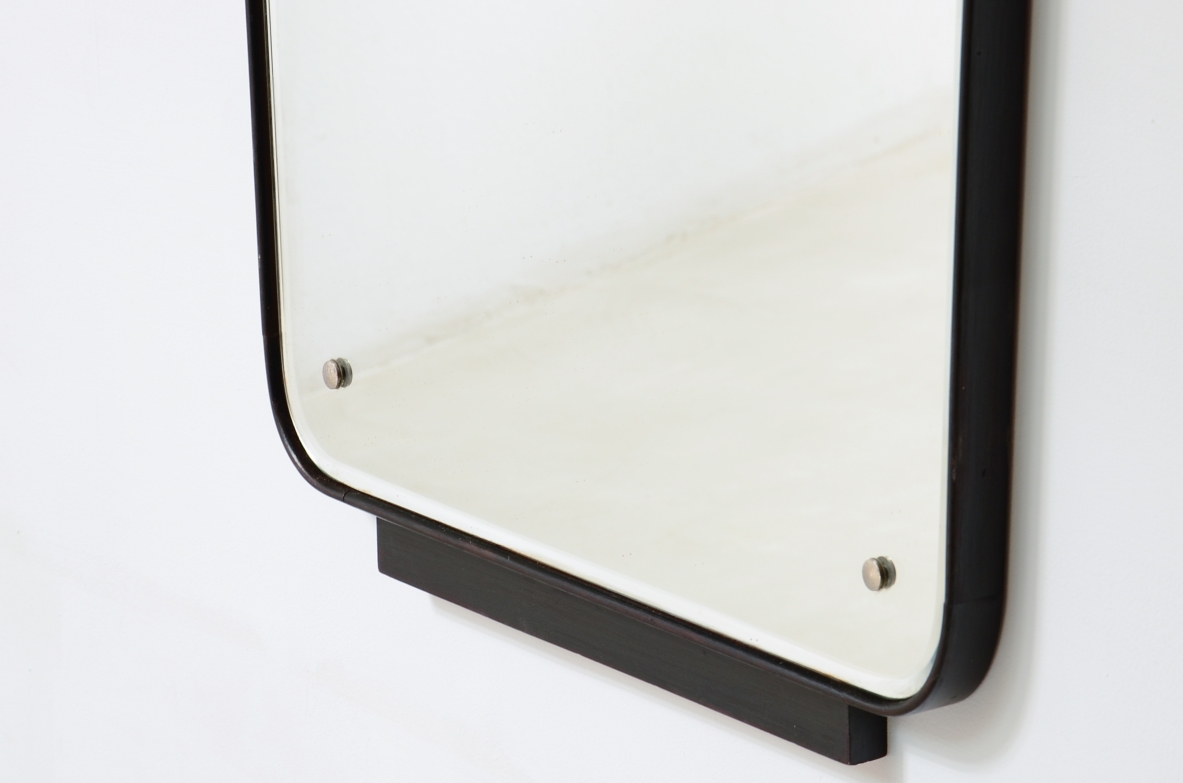 Large mirror with a shaped wooden frame. Italian manufacture, circa 1950.
