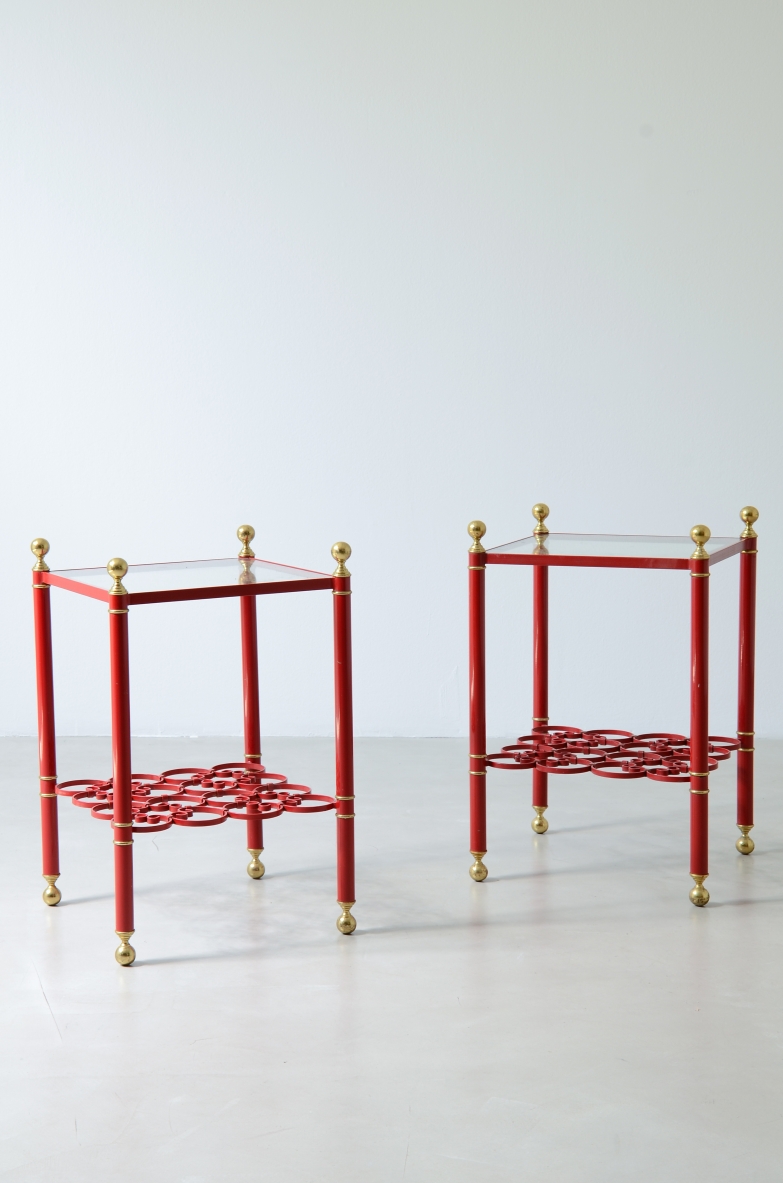 Pair of 1960s lacquered metal side tables with brass details, shaped metal shelves and beveled glass tops.