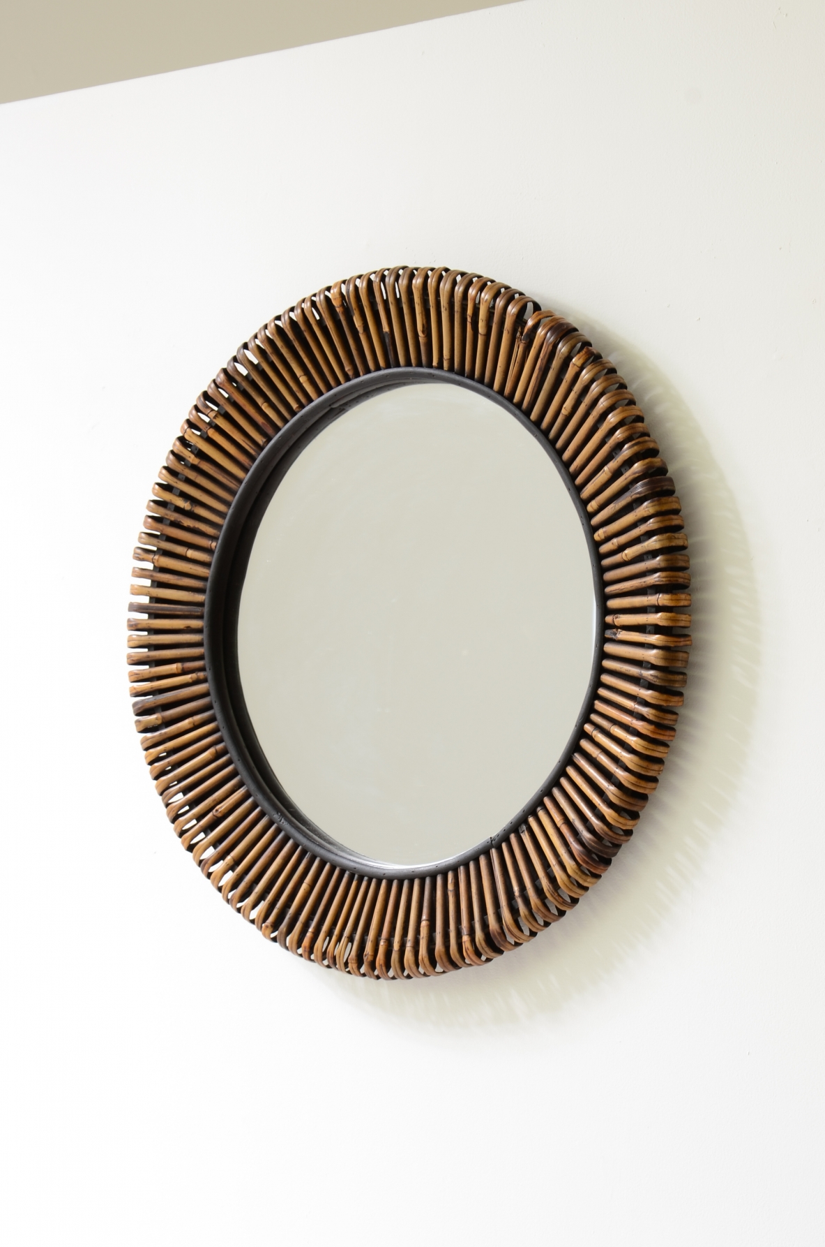 Beautiful mirror with a sunburst cane frame.  Italian manufacture, circa 1950-60.