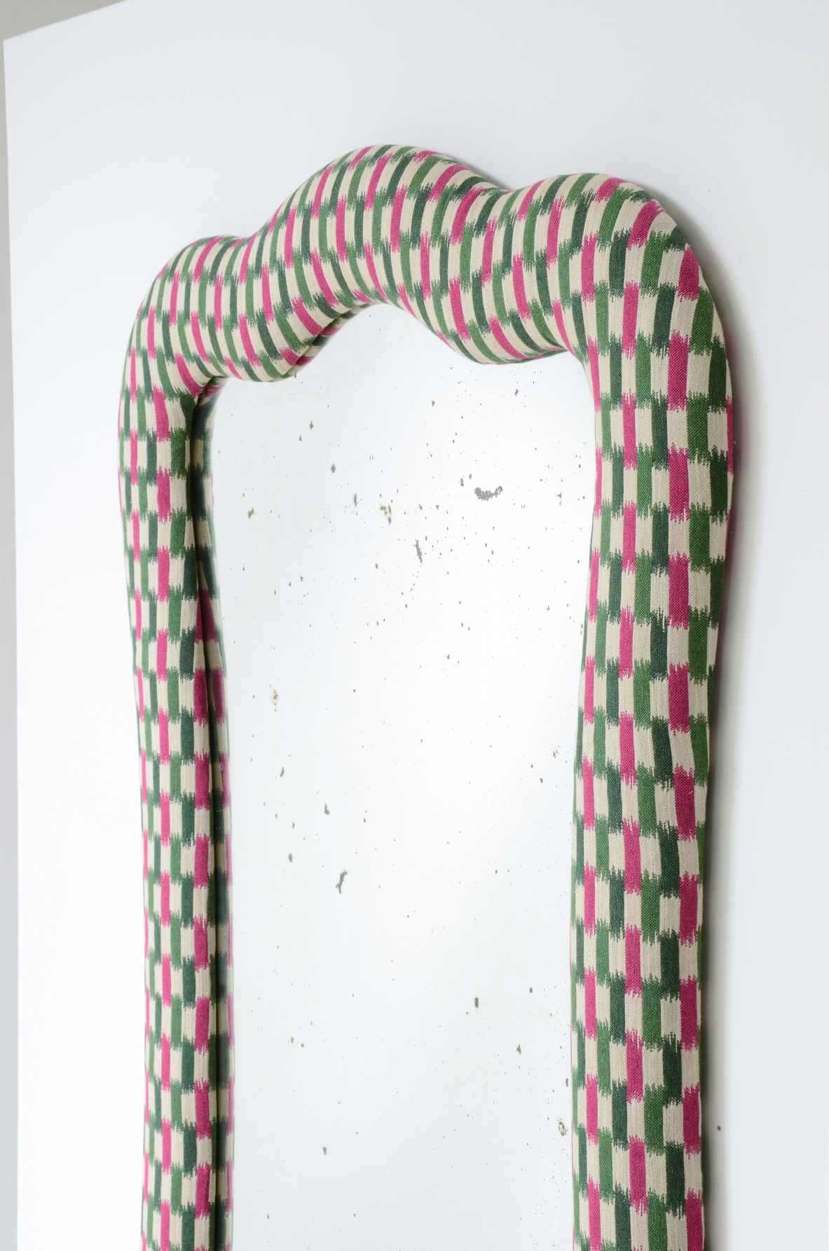 Grande specchiera con cornice sagomata e rivestimento in tessuto. Italia 1800-1900