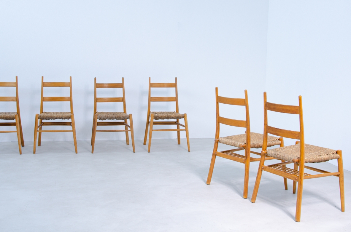 Group view of six Danish chairs attributed to Kaare Klint, in light wood with horizontal ladder backrests and woven straw seats.