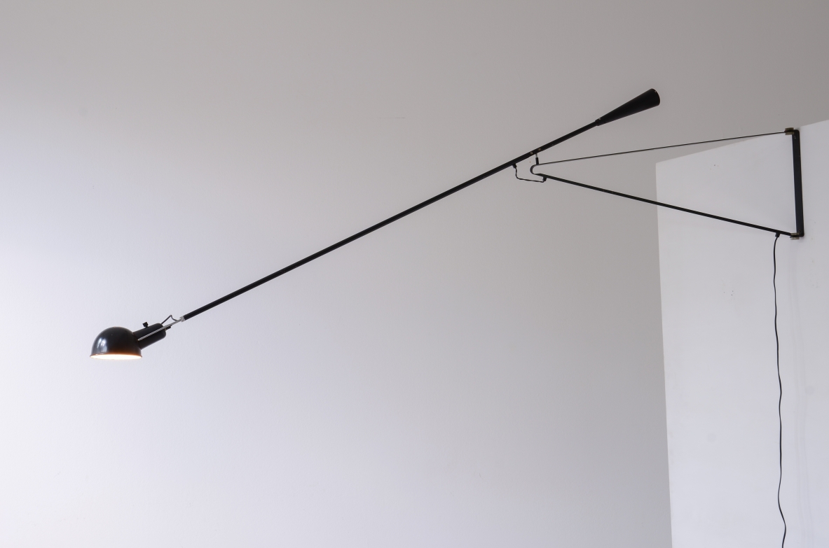Paolo Rizzatto adjustable wall lamp for Arteluce, featuring a long diagonal articulated painted steel arm, small directional reflector, cast iron counterweight and geometric wall-mounted support, side view.