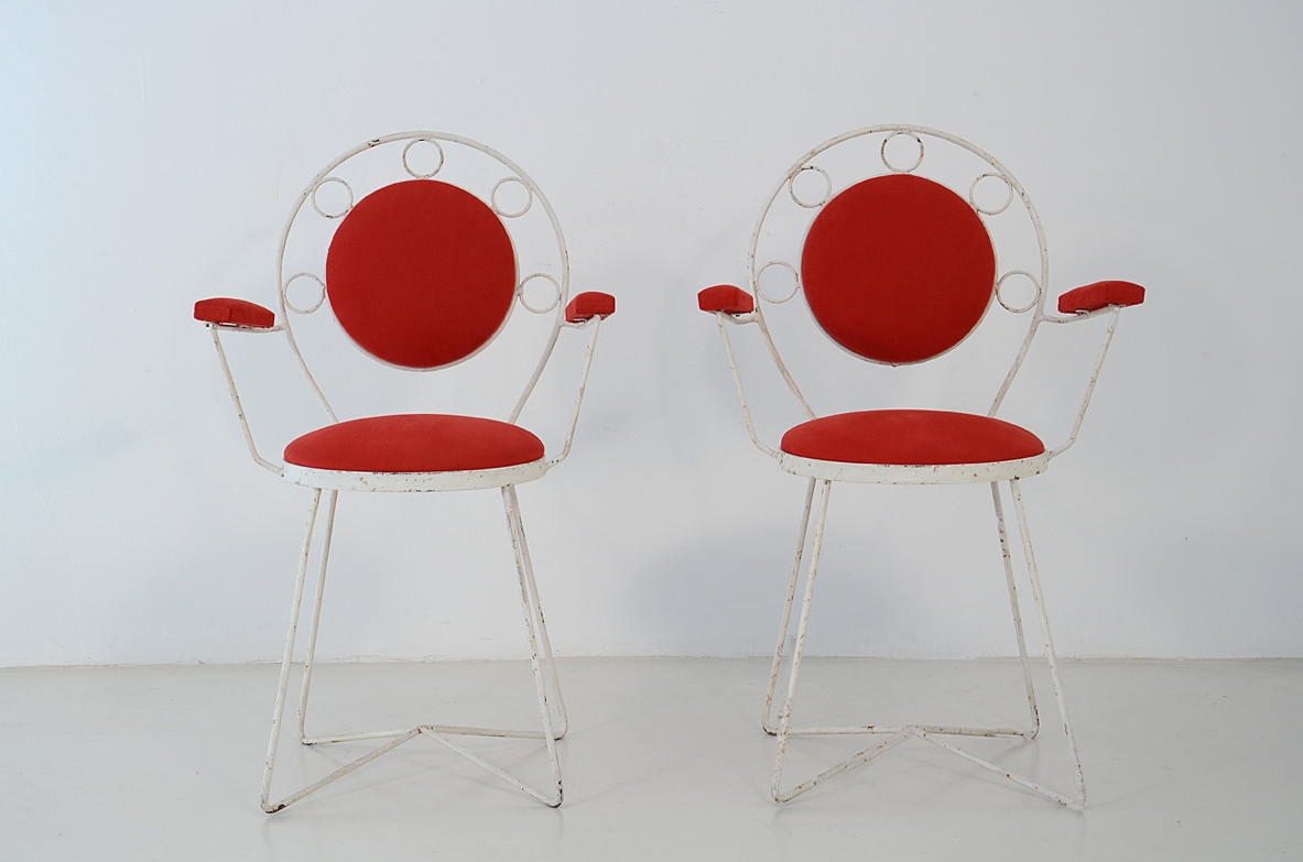Pair of Italian Margherita armchairs circa 1950, with slender metal rod frames, circular backrests, padded seats and armrests upholstered in red cotton, front view.