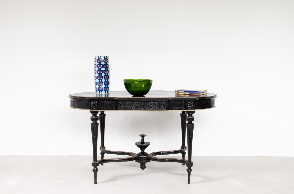 Center table in ebonized wood with thin turned legs and shaped top, brass profiles. France, 1870-1900.
