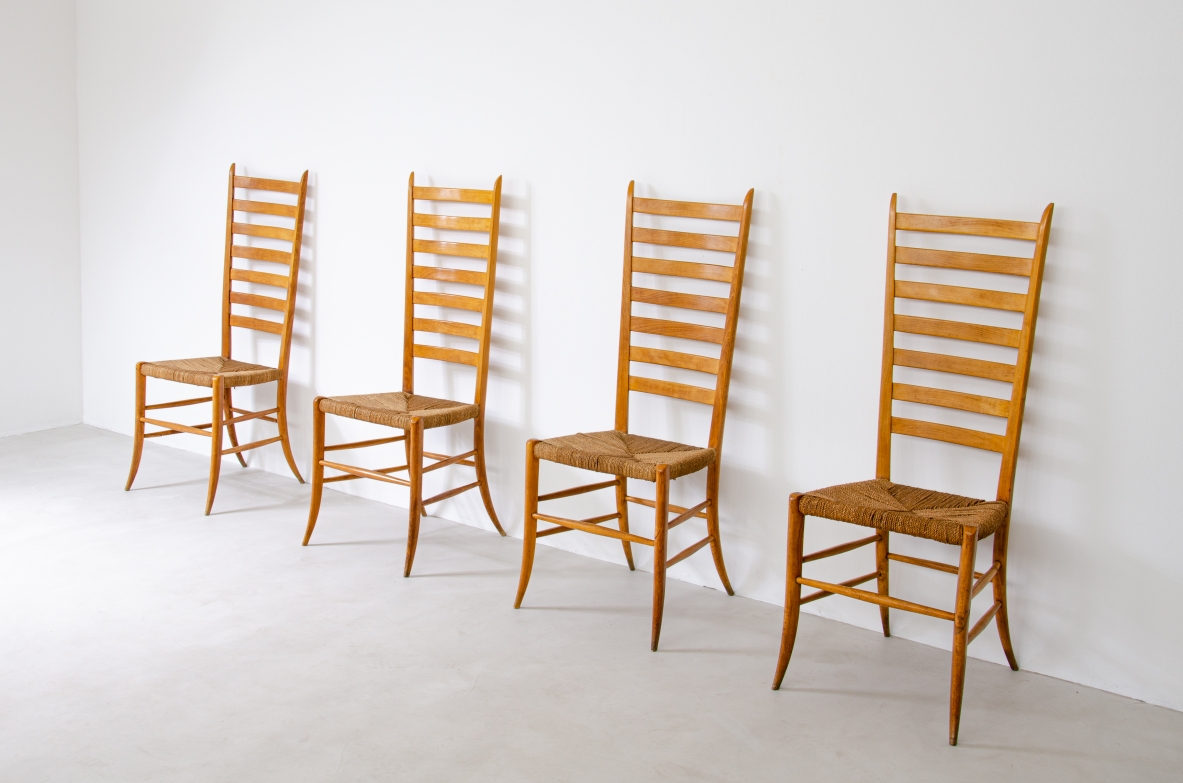 Group view of four Paolo Buffa chairs in light-colored wood, featuring tall horizontal slatted backs, woven rope seats and saber legs.