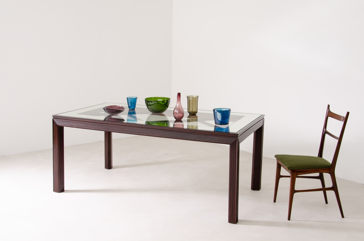 Borsani dining table, Varedo, circa 1940, with reeded wood legs and apron, rectangular glass top with mirrored perimeter and visible wooden cross structure.