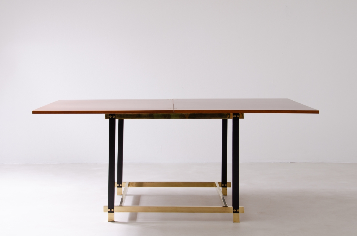 Italian extending folding table circa 1960 with rectangular mahogany top, black metal base and brass details, photographed from the front.