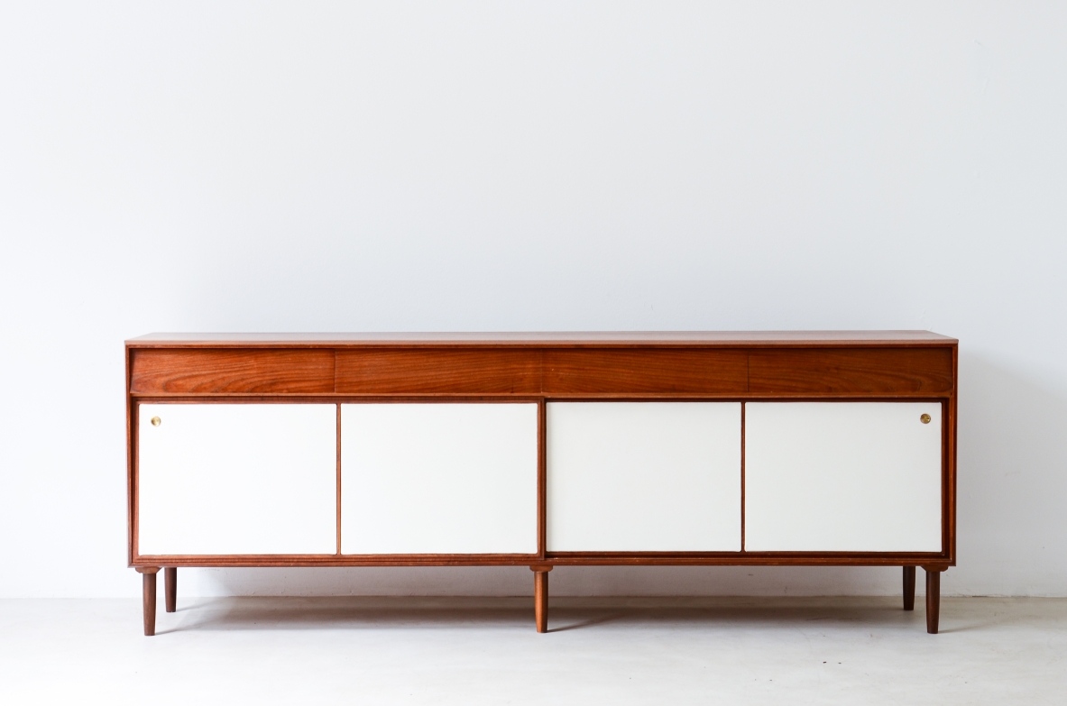 Elegant 1950's sideboard with drawers and sliding panels upholstered in leather.
