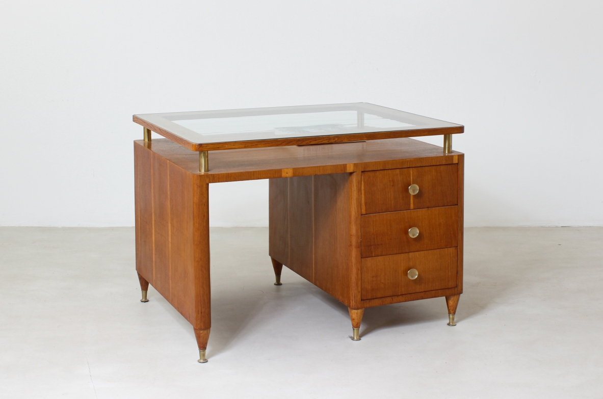 Scrivania con cassetti laterali, puntali in ottone e piano in vetro. Manifattura italiana, 1950ca. Scrivania con cassetti laterali, puntali in ottone e piano in vetro. Manifattura italiana, 1950ca.