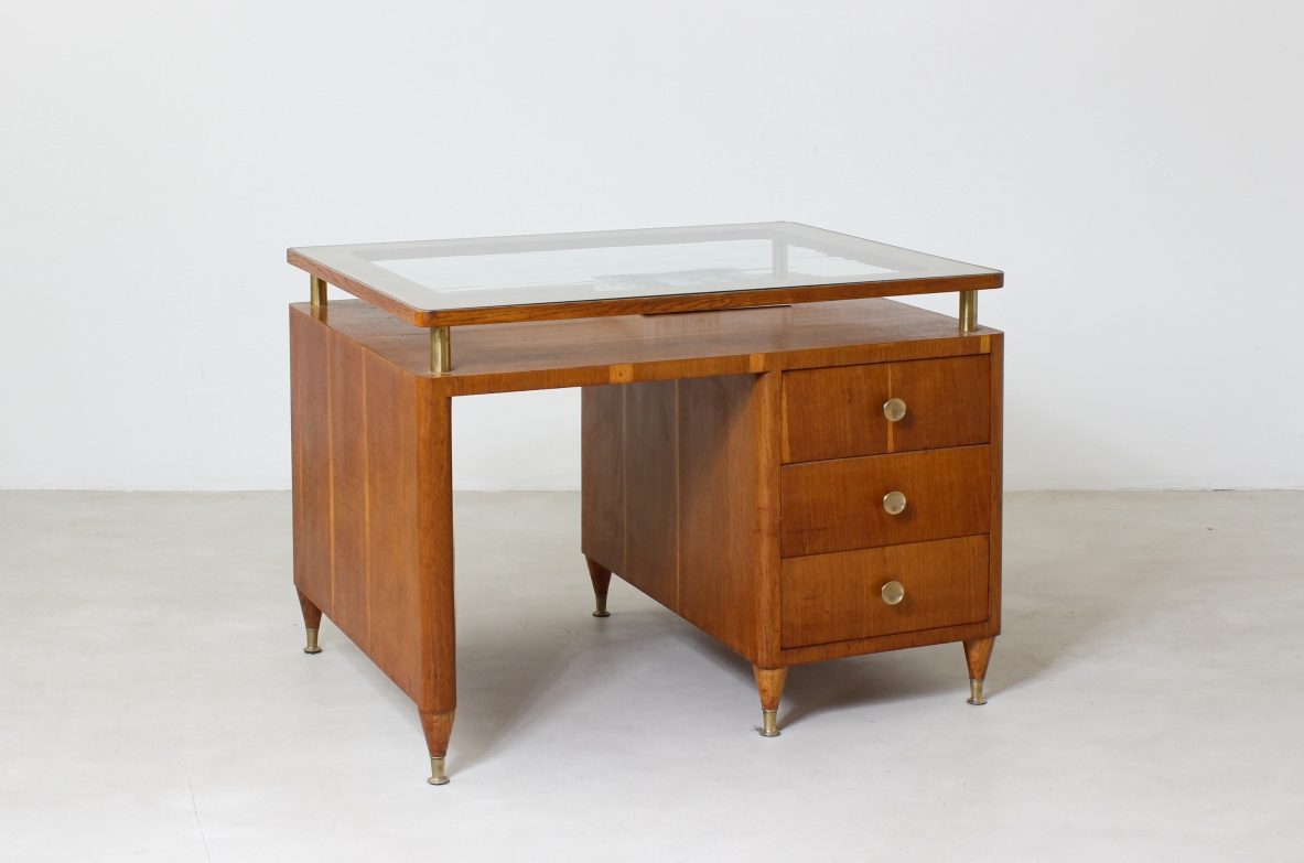 Modernist 1950's desk with side drawers, brass tips and glass top.