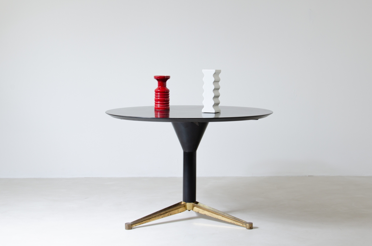 Melchiorre Bega, tavolo in legno laccato nero con base a tre razze sagomate in ottone.  Manifattura Bega & C. Bologna anni 50.