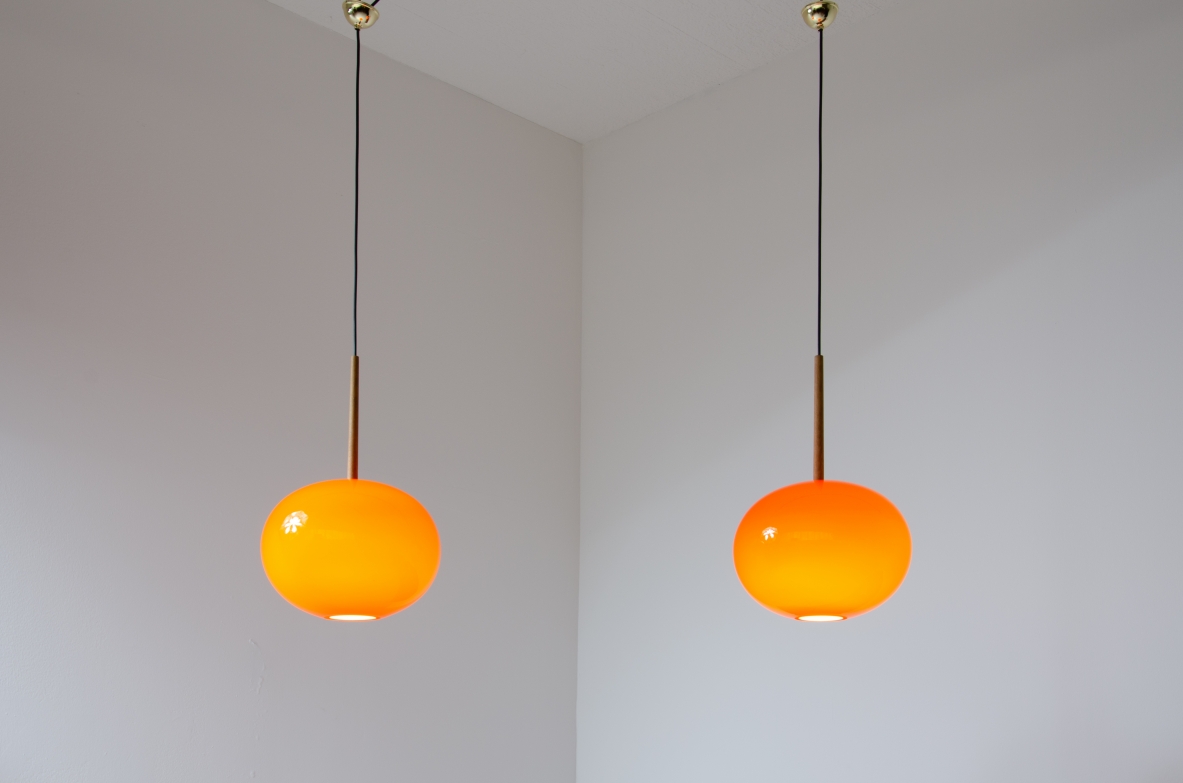 Pair of pendant chandeliers with wooden stem and red blown glass diffuser.  Scandinavia, 1950s.