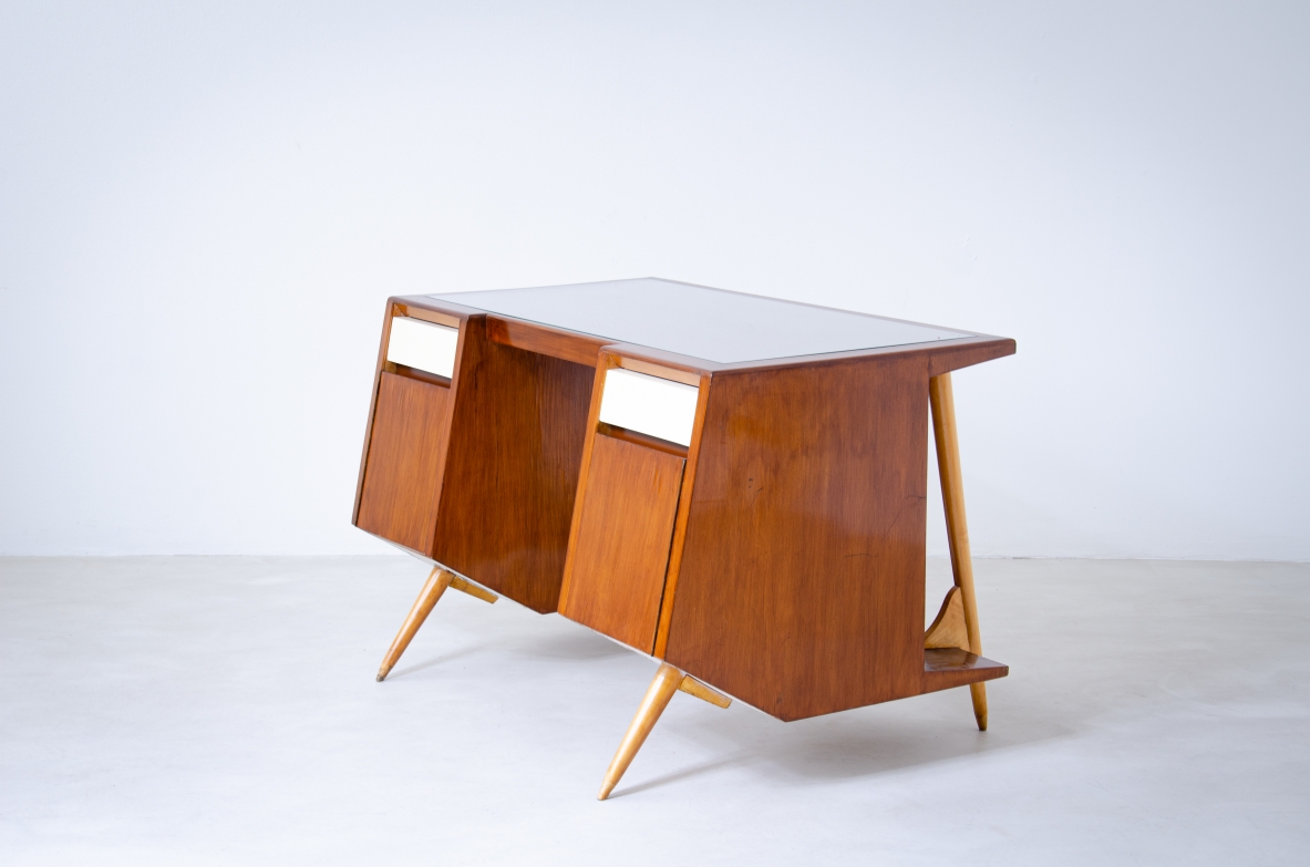 Rare Italian modernist desk by Luigi Olivieri, circa 1950, in walnut and blond maple with bevelled glass top, side doors and angled supports.