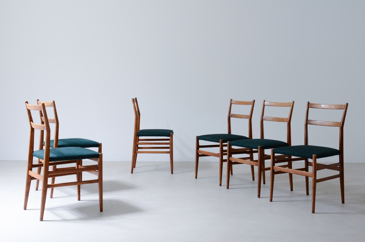 Group view of six Gio Ponti Leggera chairs by Cassina, in light oak with open backrests, dark green upholstered seats and slender wooden legs.