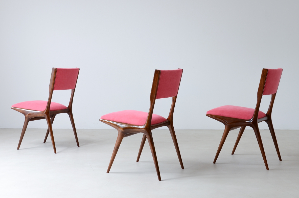 Three Carlo De Carli Model 634 chairs for Cassina, with wooden frames, angled legs and fabric-upholstered seats and backrests.
