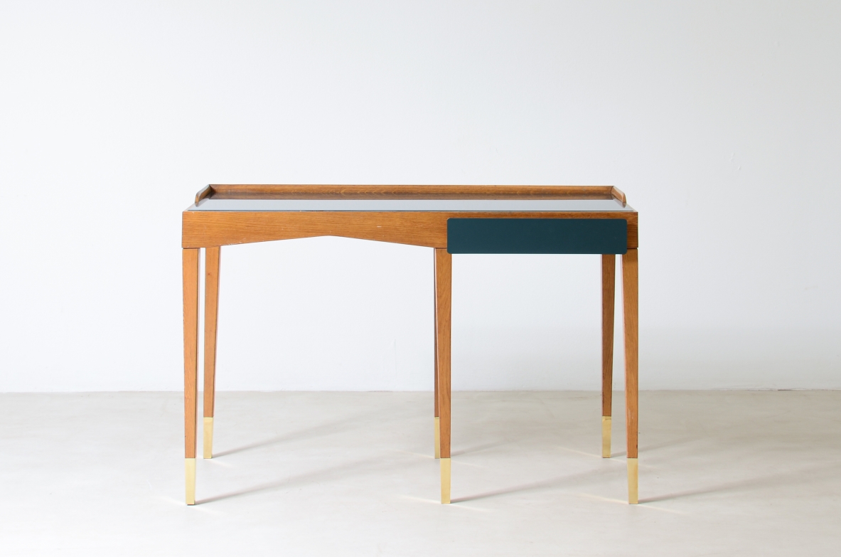 Refined oak writing desk with petrol green opaline glass top and backsplash.  Shaped drawer of the same color covered in polypropylene. Long thin legs with brass tips.  Attributed to Gio Ponti, early 1950s manufacture.