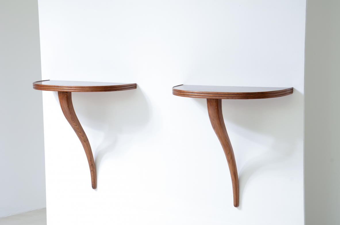 Coppia di piccole console in rovere con piano a mezzaluna e braccio di sostegno a parete.   Manifattura italiana, 1940ca