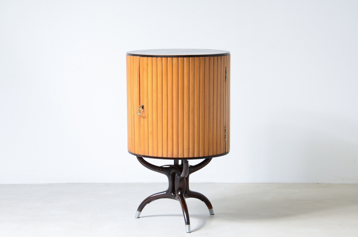 Small bar cabinet in the shape of a column in blond wood with a curved wooden base in the style of Ico Parisi.  Italian manufacture, ca. 1950.