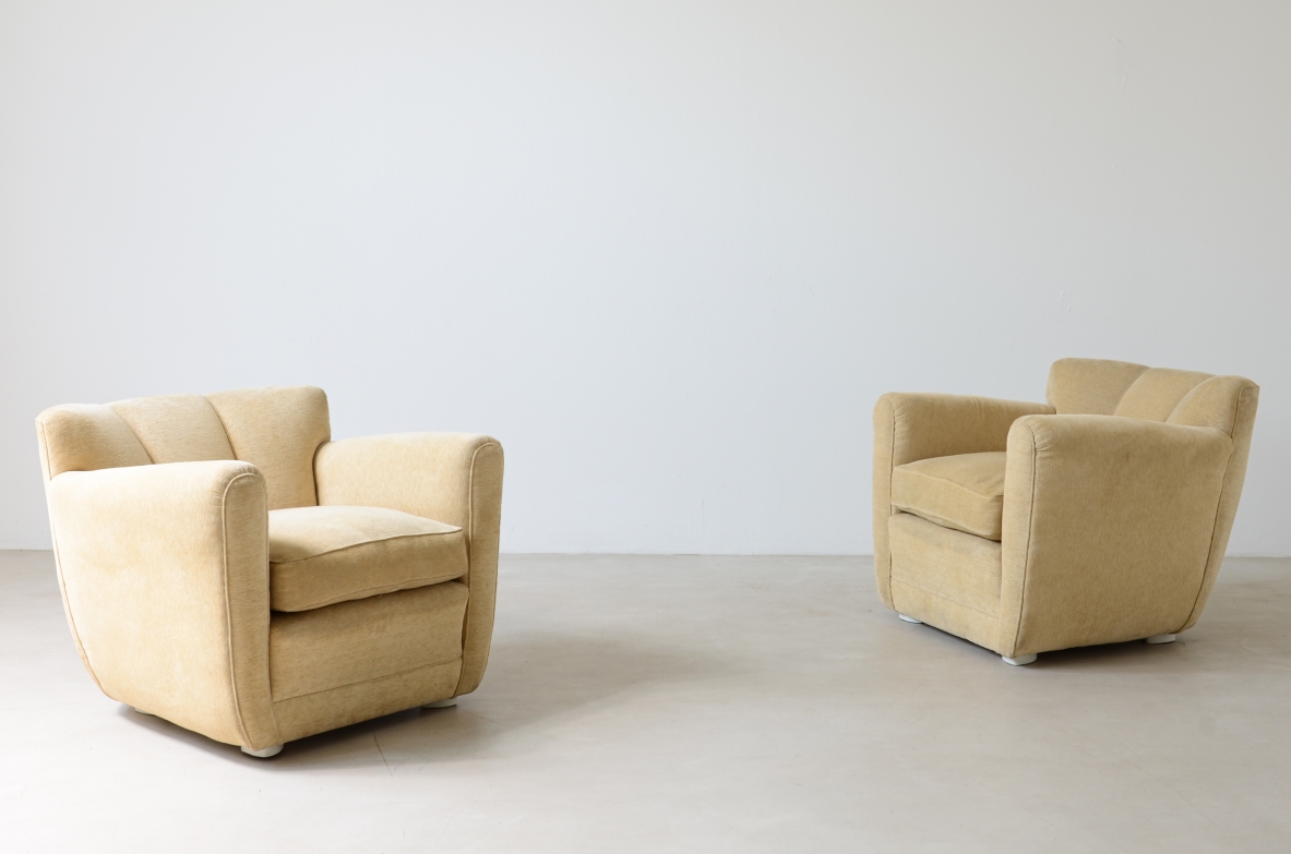 Pair of 1940s ABV Borsani armchairs with upholstered backrests, wide geometric armrests, deep seats and ivory-colored fabric upholstery.