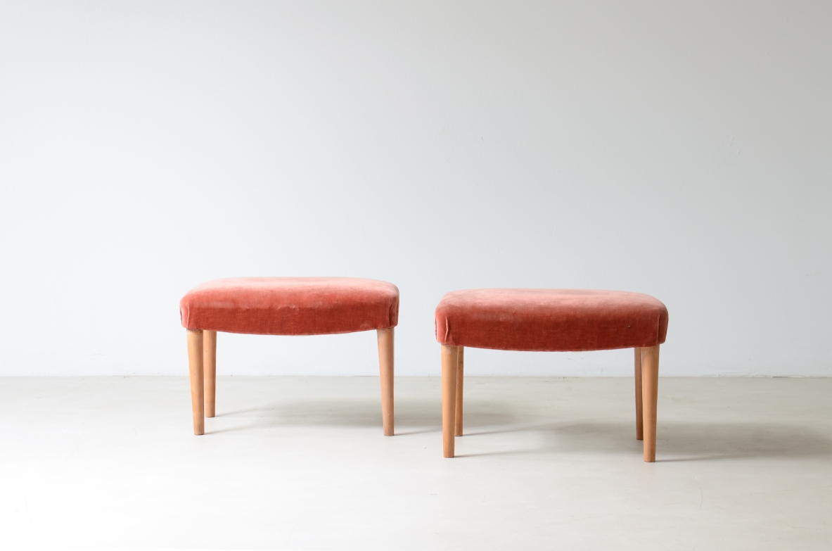 Front view of two low cherrywood benches with rectangular coral pink upholstered seats and slender tapered wooden legs.