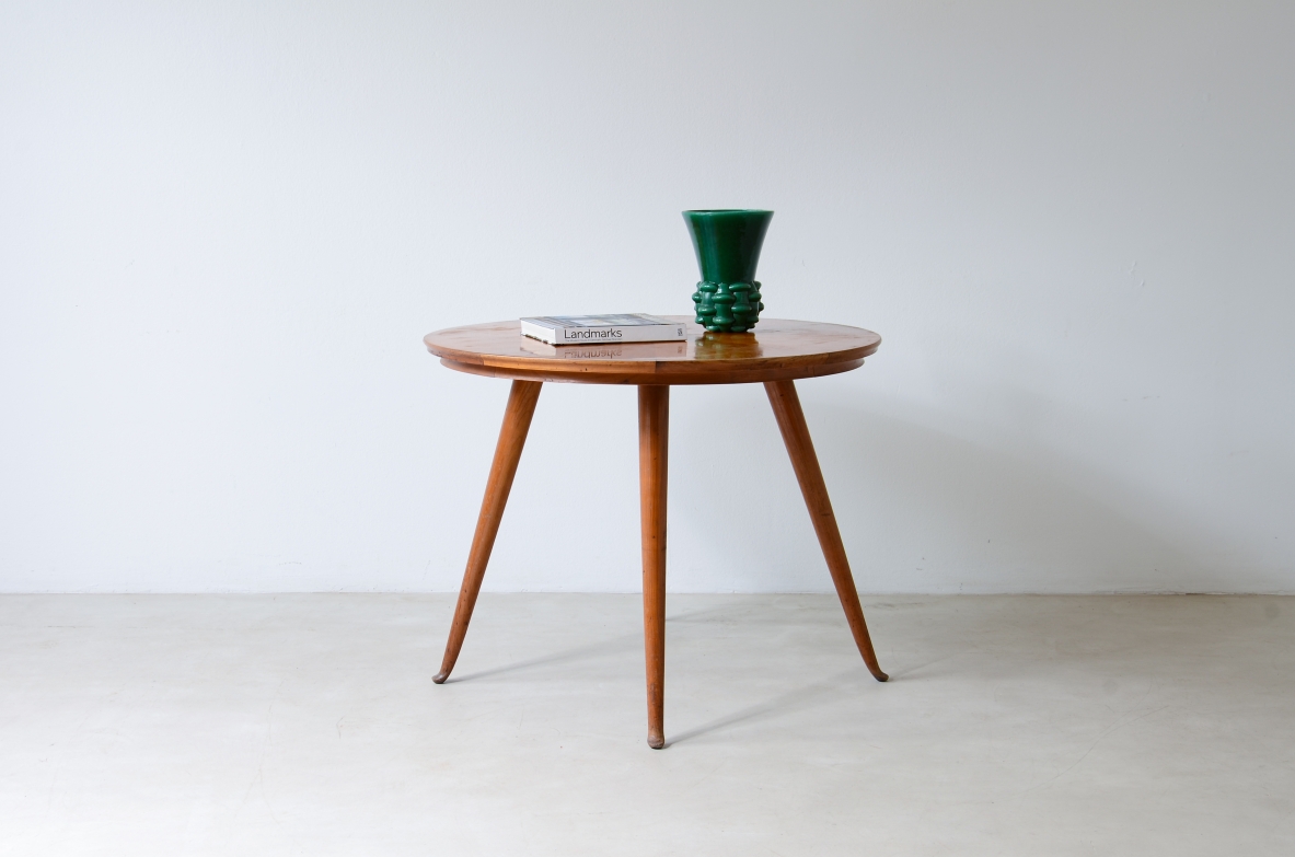 Round cherrywood table attributed to Guglielmo Ulrich, circa 1950, with veneered top and three slender tapered legs, front view with green vase on top.
