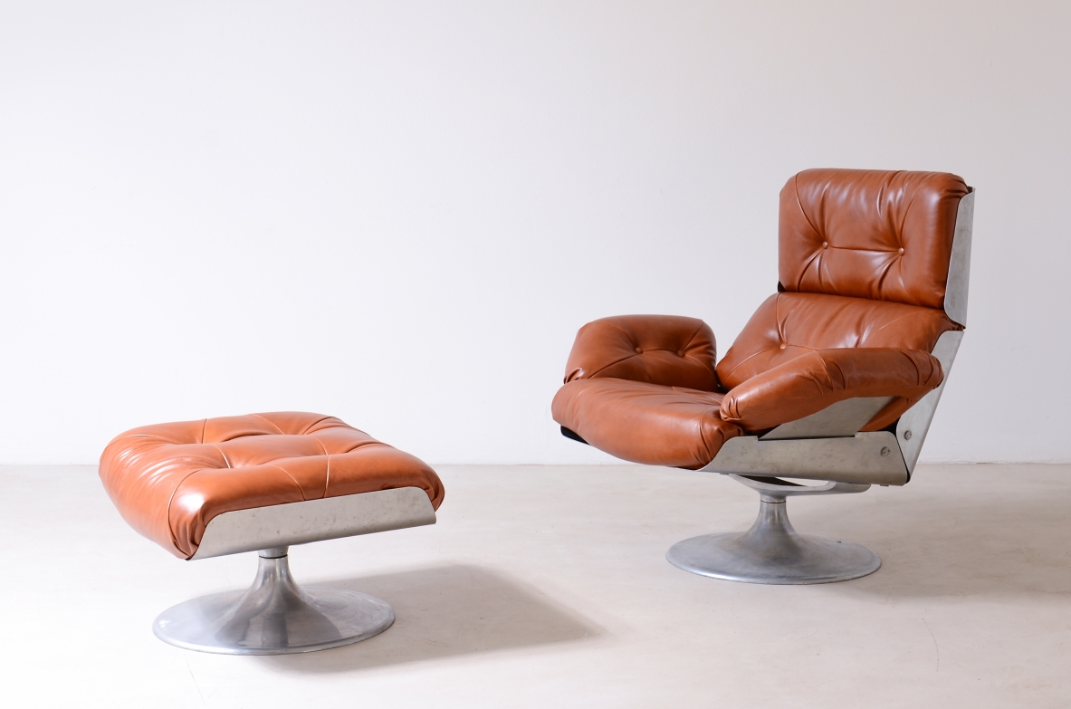 Xavier Feal swivel lounge chair and matching ottoman, upholstered in cognac-colored tufted leather, with curved steel frames and circular metal pedestal bases.